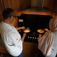 two people cooking over home stove